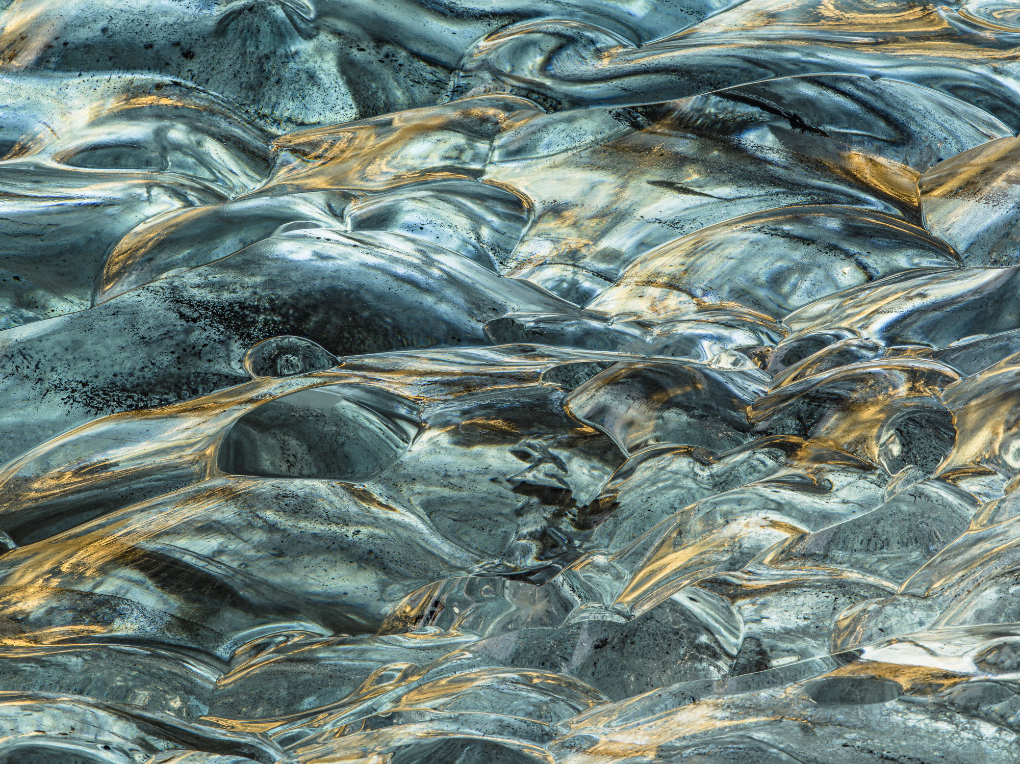 Sunlight bounces off icy waves and makes beautiful patterns on the Sapphire ice cave's ceiling in Iceland's Jökulsárlón glacier.