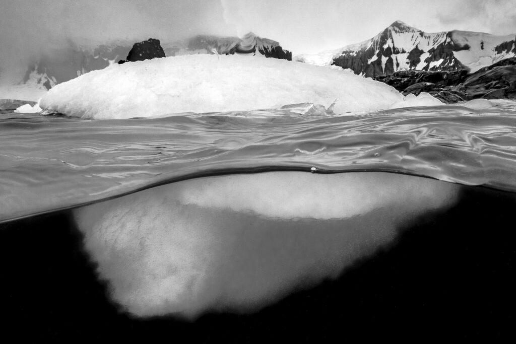 An iceberg floats along the shoreline in the Antarctic Peninsula