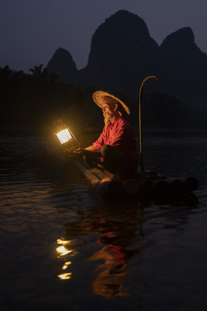 A cormarant fisherman at night in Erhai Lake in Yunnan province, China.