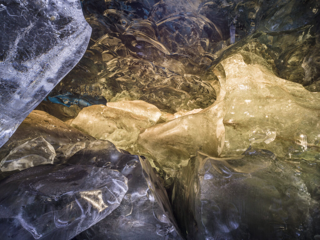 The last rays of evening sunlight turn giant blocks of ice into jewels in a remote ice cave in Iceland's J&ouml;kuls&aacute;rl&oacute;n glacier.