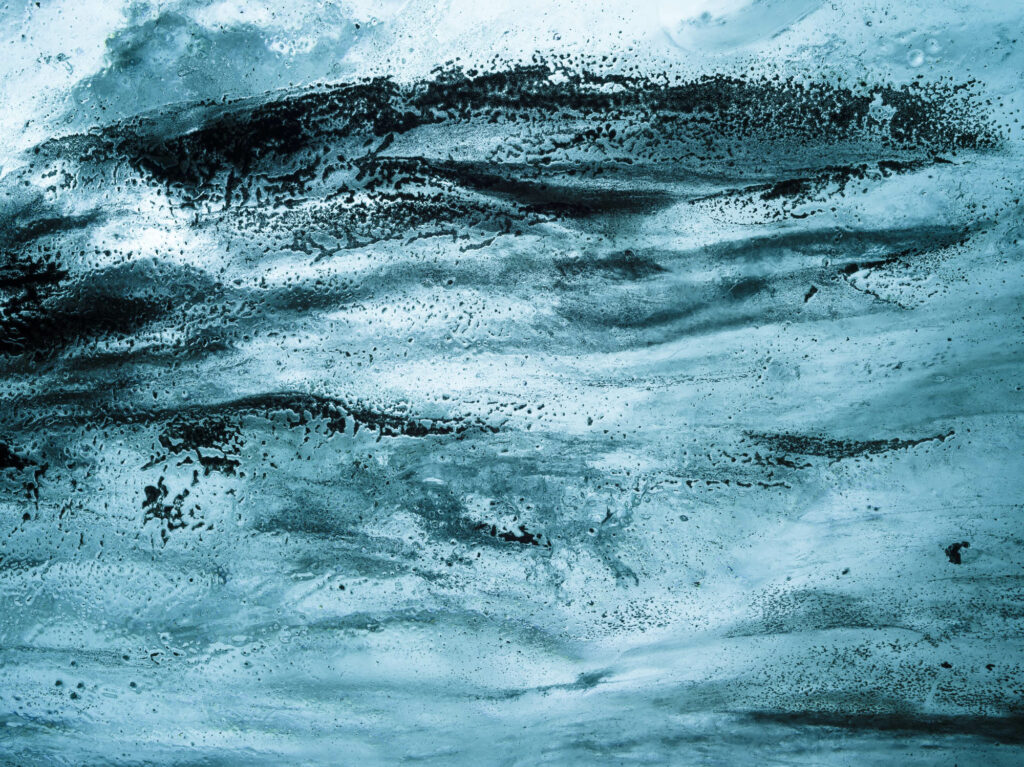 Volcanic ash embedded in the celing looks like an abstract painting in Saphire ice cave's ceiling in Iceland's J&ouml;kuls&aacute;rl&oacute;n glacier.