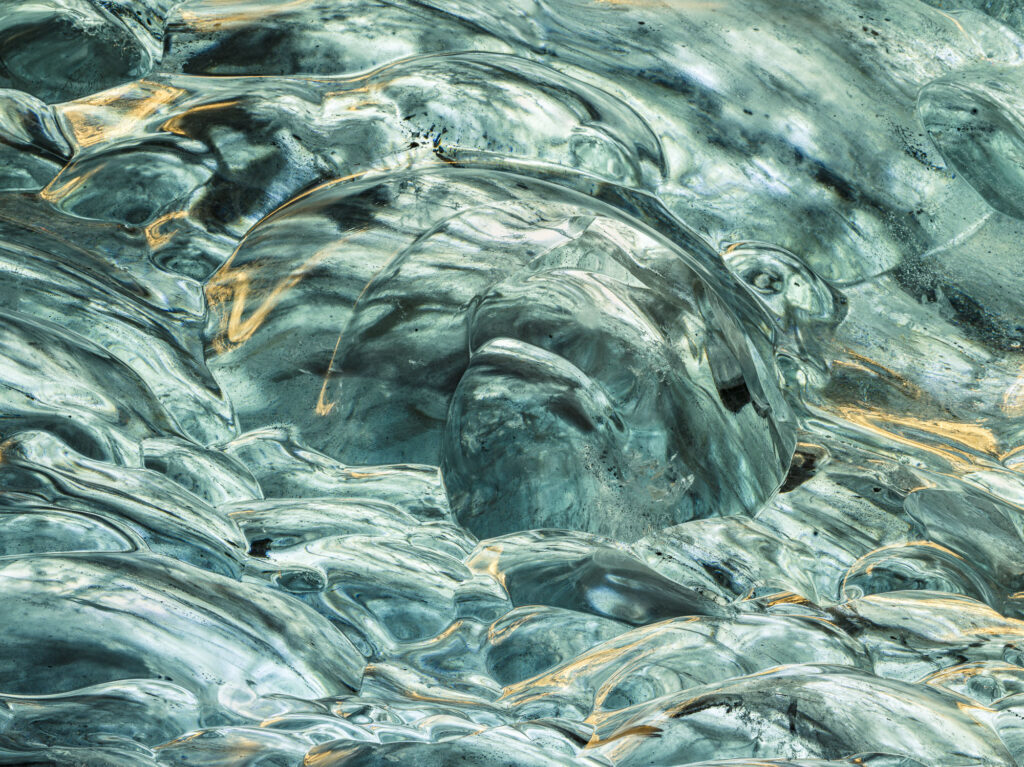 Sunlight bounces off the ice bubbles and makes beautiful paterns on the Saphire ice cave's ceiling in Iceland's J&ouml;kuls&aacute;rl&oacute;n glacier.