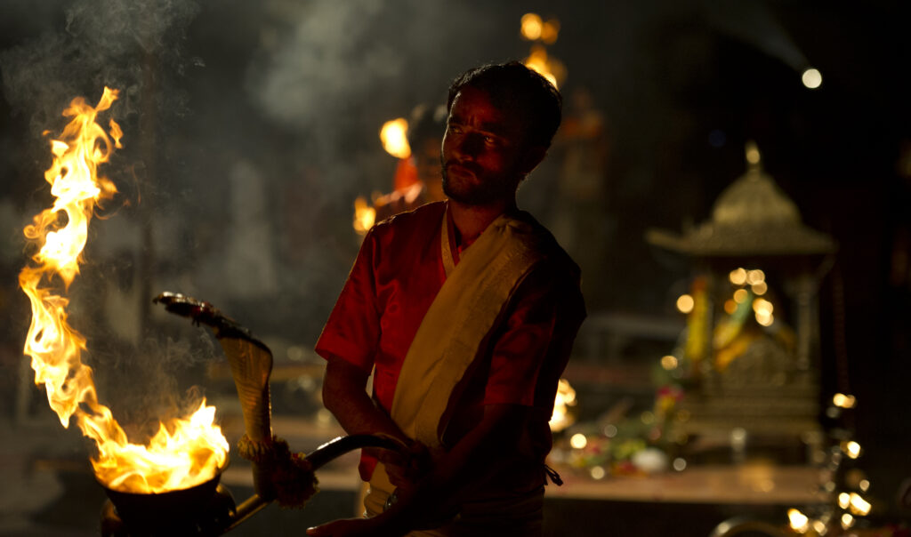 A sadhu performs an evening prayer ritual in Varanasi.