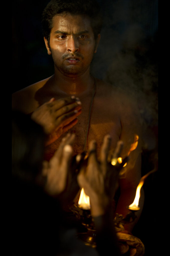 A sadhu prays above a lamp at night in Varanasi.