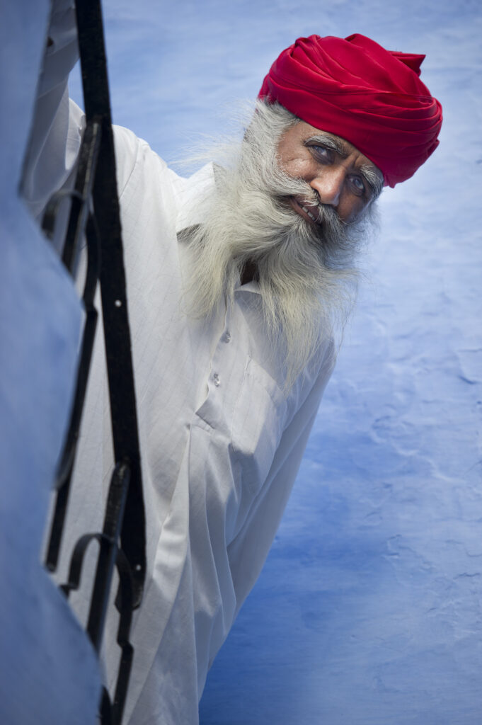 An old man climbs down the stairs in Johdpur.