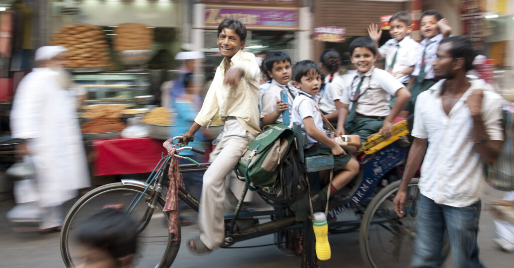 School children riding to school in a rickshaw in Old Delhi
