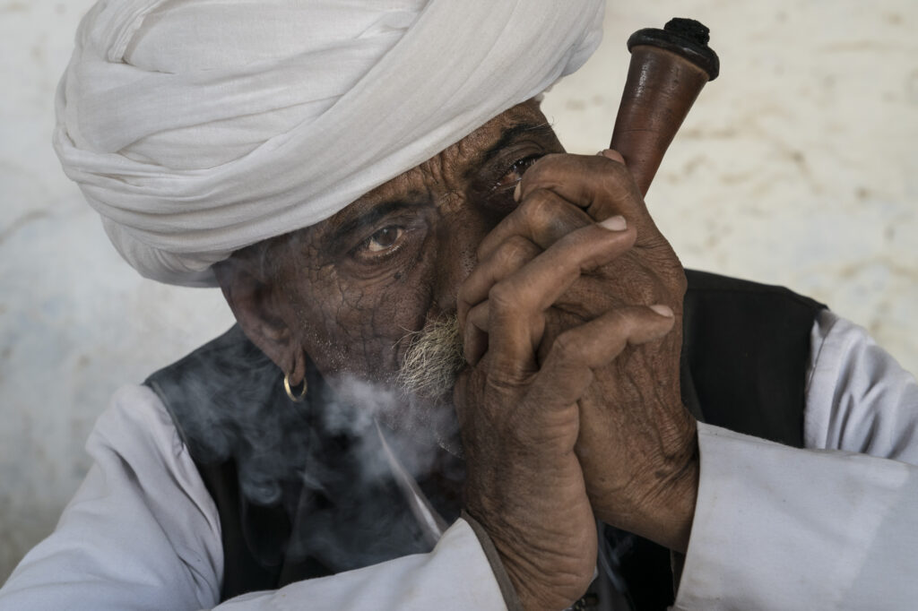 An old farmer smokes a pipe near Johdpur.