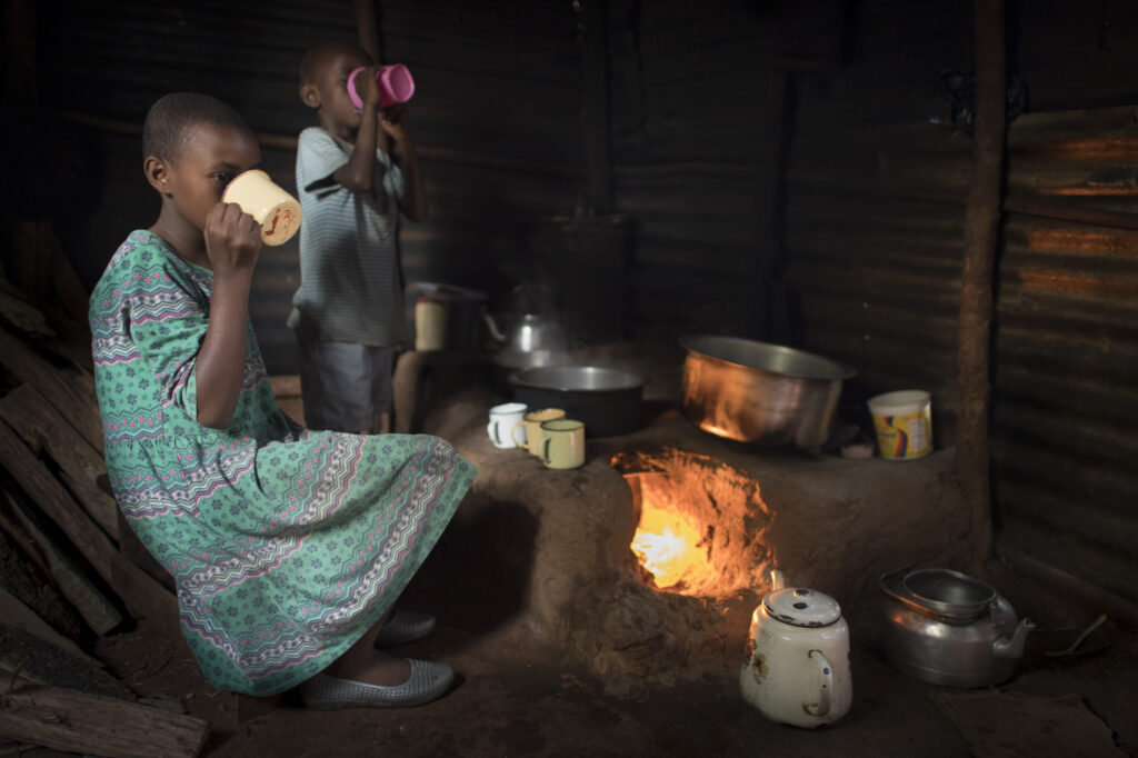 At home with a two Maasai children while they enjoy chai (tea).