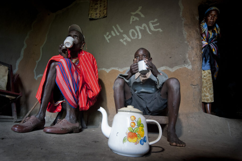 At home with a Maasai family while they enjoy chai (tea).