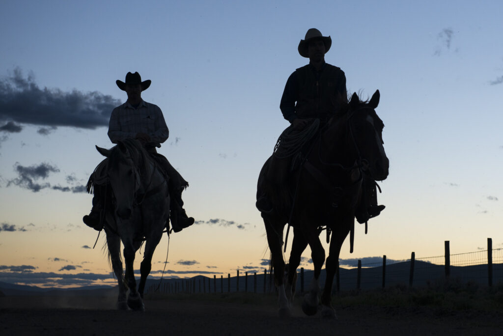 Cowboys riding home at the end of the day.