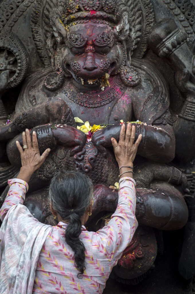 An old woman prays to an idol near Bhaktapur's Durbar Square
