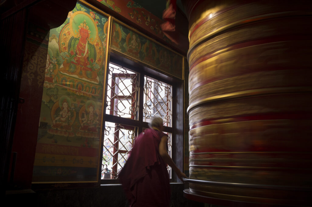 An old monk spins a prayer wheel in Kathmandu