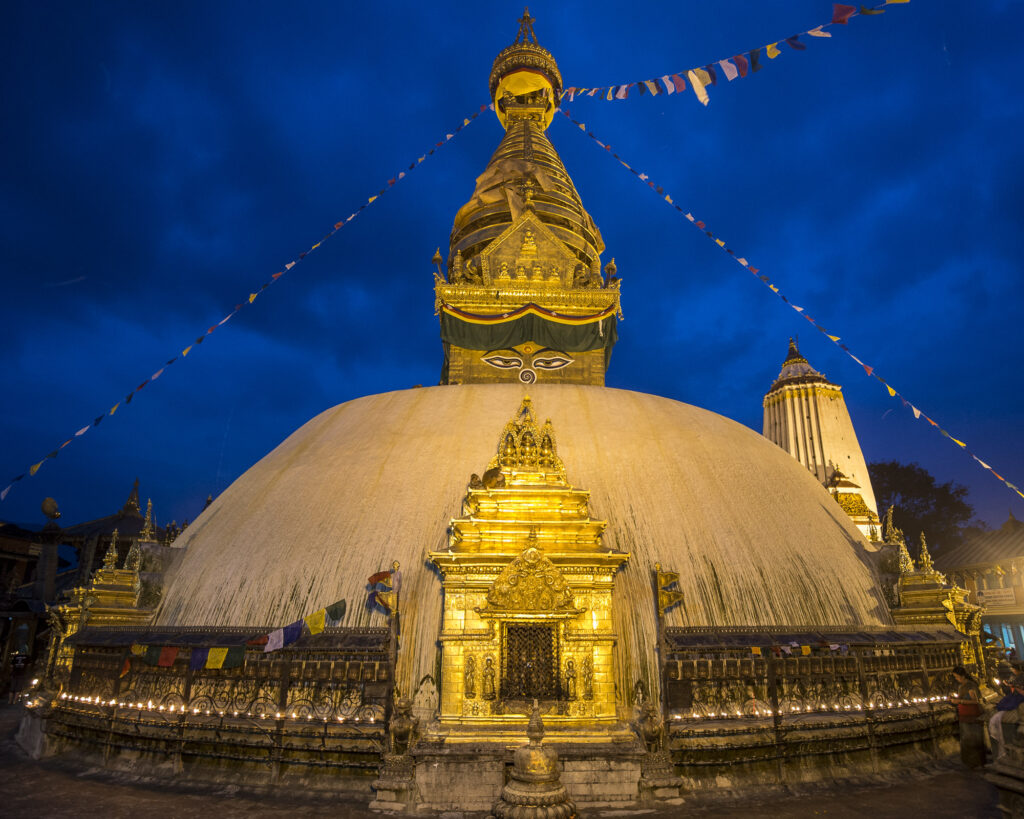 A worshipper lights a candle at a stupa in Kathmandu.