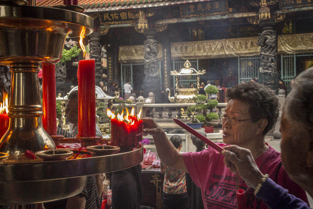 Worshippers light candles in Longshan Temple, Taipei, Taiwan
