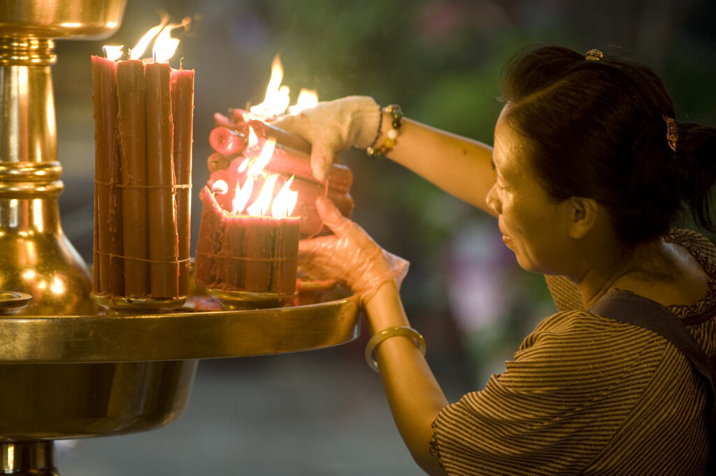 A worshiper lights candles at Longshan Temple, Taipei, Taiwan