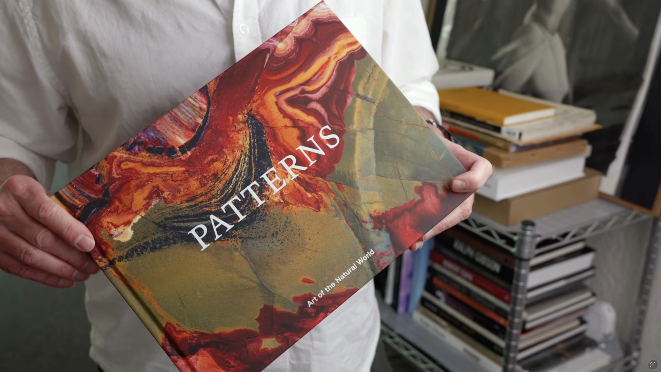 Artist holding book, showing only hands and the book.